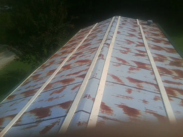 Rusted metal roof panels with new wood purlins before replacement — Storm Damage Roof Repair in Cross City by Roofing Brothers